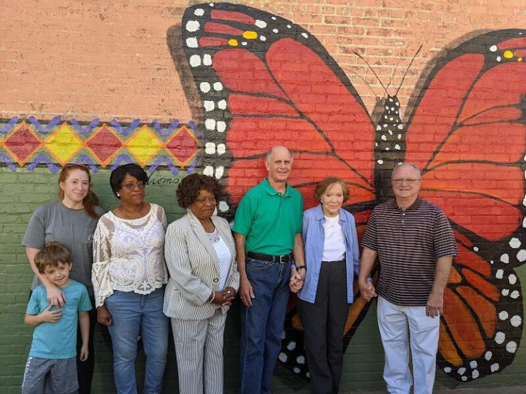Group standing in front of wall mural at Cafe Campesino
